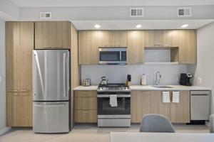 a kitchen with stainless steel appliances and wooden cabinets at WhyHotel by Placemakr, Alexandria in Alexandria