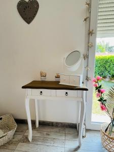 - une coiffeuse avec un miroir au-dessus dans l'établissement Un coin tropical en Provence !, à LʼIsle-sur-la-Sorgue