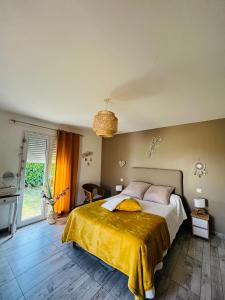 - une chambre avec un grand lit et une couverture jaune dans l'établissement Un coin tropical en Provence !, à LʼIsle-sur-la-Sorgue