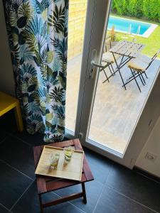 une table en face d'une porte avec vue sur un patio dans l'établissement Un coin tropical en Provence !, à LʼIsle-sur-la-Sorgue