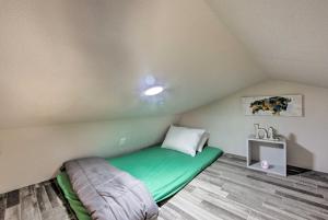 een kleine kamer met een groen bed op zolder bij Lake Fork Tiny Home Outdoor Dining and Grill! in Alba