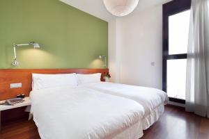 Un dormitorio con una gran cama blanca y una ventana en Inside Barcelona Apartments Mercat en Barcelona