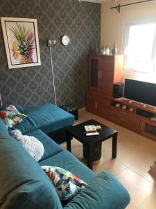 a living room with two blue couches and a tv at "La Piña" Condado Golfresort 1574 in Alhama de Murcia