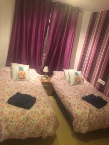 two beds in a room with purple curtains at "La Piña" Condado Golfresort 1574 in Alhama de Murcia +30 photos
