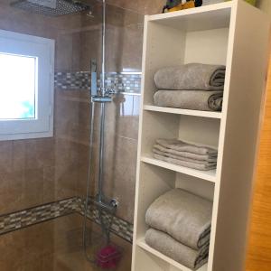 a bathroom with a shower and towels on shelves at "La Piña" Condado Golfresort 1574 in Alhama de Murcia