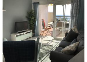 - un salon avec un canapé et une télévision dans l'établissement Sunny apartment on Burriana Beach, à Nerja