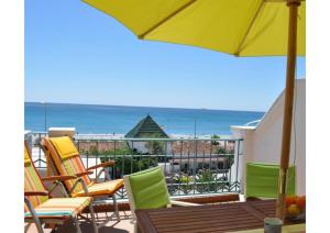 - un balcon avec des chaises et un parasol dans l'établissement Sunny apartment on Burriana Beach, à Nerja
