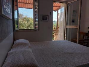 a bedroom with a bed and a large window at La Dimora dei Pescatori in Vieste