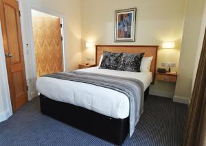 a bedroom with a large bed in a hotel room at Royal Athenaeum Suites in Aberdeen