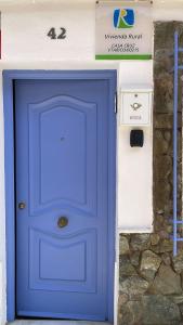 a blue door on a building with a stone wall at Casa Cruz in Almodóvar del Río