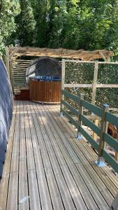 a wooden deck with a gazebo and a fence at La cabane du Panda in Abrest