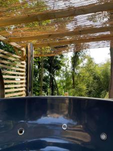 a hot tub under a wooden pergola at La cabane du Panda in Abrest