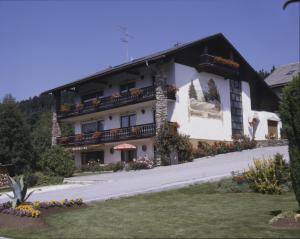 a large white building with flowers in front of it at Pension Bergblick in Bayerisch Eisenstein