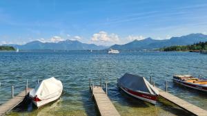 Due barche sono ormeggiate in un molo su un lago. di Hotel Schlossblick Chiemsee a Prien am Chiemsee