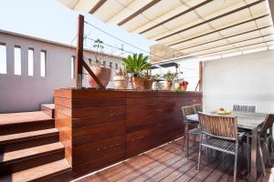 a patio with a table and chairs on a deck at Inside Barcelona Apartments Mercat in Barcelona