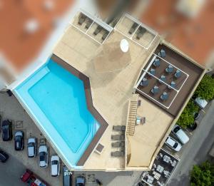 uma vista superior para uma piscina e estacionamento em Hotel Apartamento Foz Atlantida em Monte Gordo