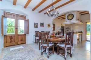 a kitchen and dining room with a wooden table and chairs at Finca Son Punta in Felanitx