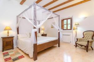 a bedroom with a canopy bed and a chair at Finca Son Punta in Felanitx +37 photos