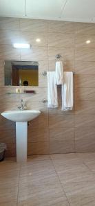 a bathroom with a sink and a mirror and towels at Legend Hotel Skardu in Skardu