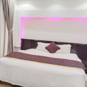 1 dormitorio con 1 cama blanca grande y cabecero negro en Evan Suites Serviced Apartments, en Riad