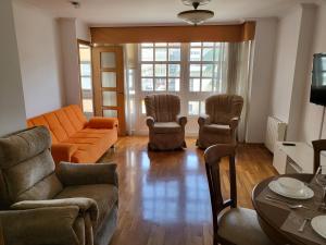 a living room with a couch and chairs and a table at Piso céntrico 2 habitaciones a escasos metros de Maria Pita in A Coruña +12 photos