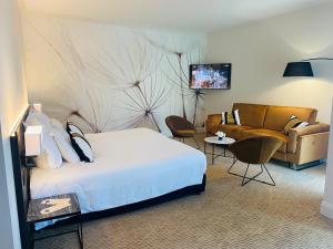 a hotel room with a bed and a couch at Palmyra Golf Hotel & Spa in Cap d'Agde