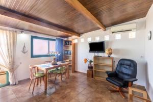 a living room with a table and chairs and a television at Apartamento B Armonia Rural in Granadilla de Abona