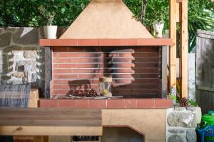 an outdoor brick oven with a pot on top at Villa Menie - Golden Fig Sykia lodge in Paralia Sikias