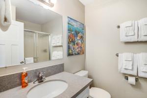 Un baño con lavabo, inodoro y espejo. en Sweethaven - 3 bedroom, en Rockaway Beach 28 fotos más