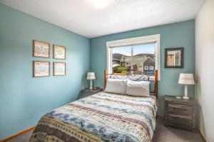 Un dormitorio azul con una cama y una ventana. en Sweethaven - 3 bedroom, en Rockaway Beach