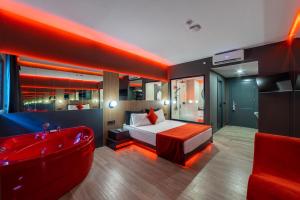 1 dormitorio con bañera roja, cama y bañera en Amon Hotels Belek - Adult Only, en Belek
