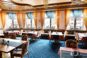 a restaurant with tables and chairs and windows at Hotel Maselheimer Hof in Maselheim