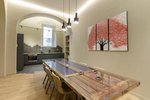 a kitchen with a large wooden table and chairs at Crociferi Luxury Apartment in Catania