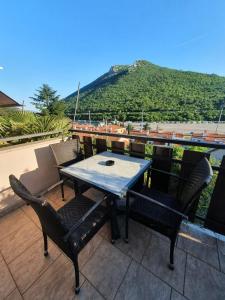 un tavolo e sedie su un balcone con vista sulle montagne di Studio Elvis a Plomin (Fianona)