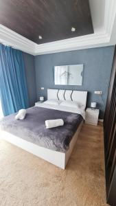 a bedroom with a large bed with blue walls at Ski INN Atrium Gudauri in Gudauri
