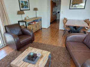 a living room with a couch and a table at Chalet nr. 9 Resort Venetië in Giethoorn