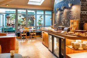 a restaurant with a counter with food on it at Ibis Styles St Etienne - Gare Chateaucreux in Saint-Étienne +63 photos