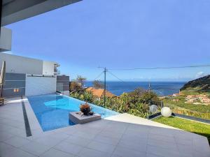 ein Swimmingpool mit Blick auf das Meer in der Unterkunft Noah - Private Sunset Hideaway by LovelyStay in Arco da Calheta