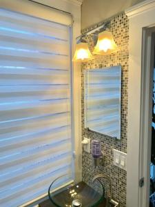 a bathroom with a glass sink and a mirror at Historical Neighborhood Home in New Rochelle
