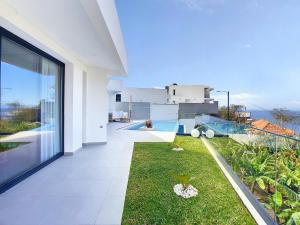 Casa blanca grande con vistas a un patio en Noah - Private Sunset Hideaway by LovelyStay, en Arco da Calheta