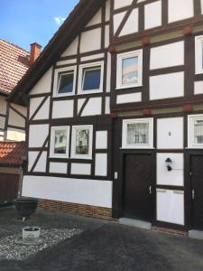 a half timbered house with two garage doors at Gemütliche Ferienwohnung im Fachwerkhaus, 1 Schlafzimmer, Balkon, Parkplatz -1 in Wolfhagen