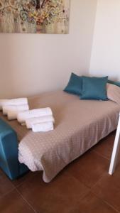 - un lit avec des oreillers et des serviettes bleus dans l'établissement VILLA SESIFE Avola, à Avola