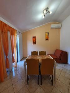 a dining room with a table and chairs and a couch at Studio Elvis in Plomin