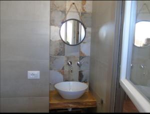 La salle de bains est pourvue d'un lavabo et d'un miroir. dans l'établissement VILLA SESIFE Avola, à Avola