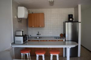 a kitchen with a counter and a refrigerator and stools at Apartamentos Mayagüez - Adults Only in Puerto Rico de Gran Canaria