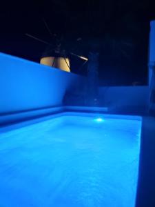 eine Person, die nachts einen Regenschirm in einem Pool hält in der Unterkunft apartamento el molino con piscina privada in Las Negras