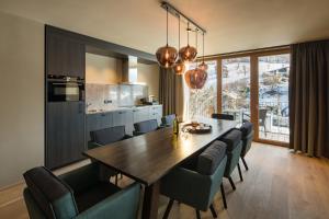 eine Küche und ein Esszimmer mit einem Holztisch und Stühlen in der Unterkunft APART Resort Schruns in Schruns-Tschagguns