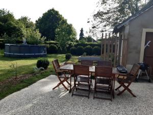 Le Loft في Sancergues: طاولة وكراسي خشبية على الفناء