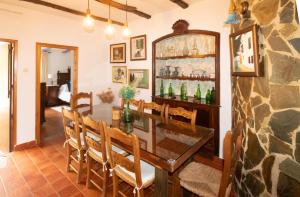 a dining room with a table and chairs and a stone wall at Casa Rural La Pedra in Ronda +42 photos