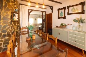 a dining room with a glass table and chairs at Casa Rural La Pedra in Ronda